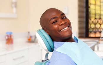 Smiling man visiting his Rochester dentist for cavity repair